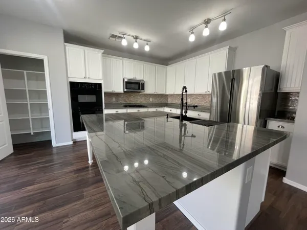 a kitchen with stainless steel appliances granite countertop a sink a stove and a refrigerator