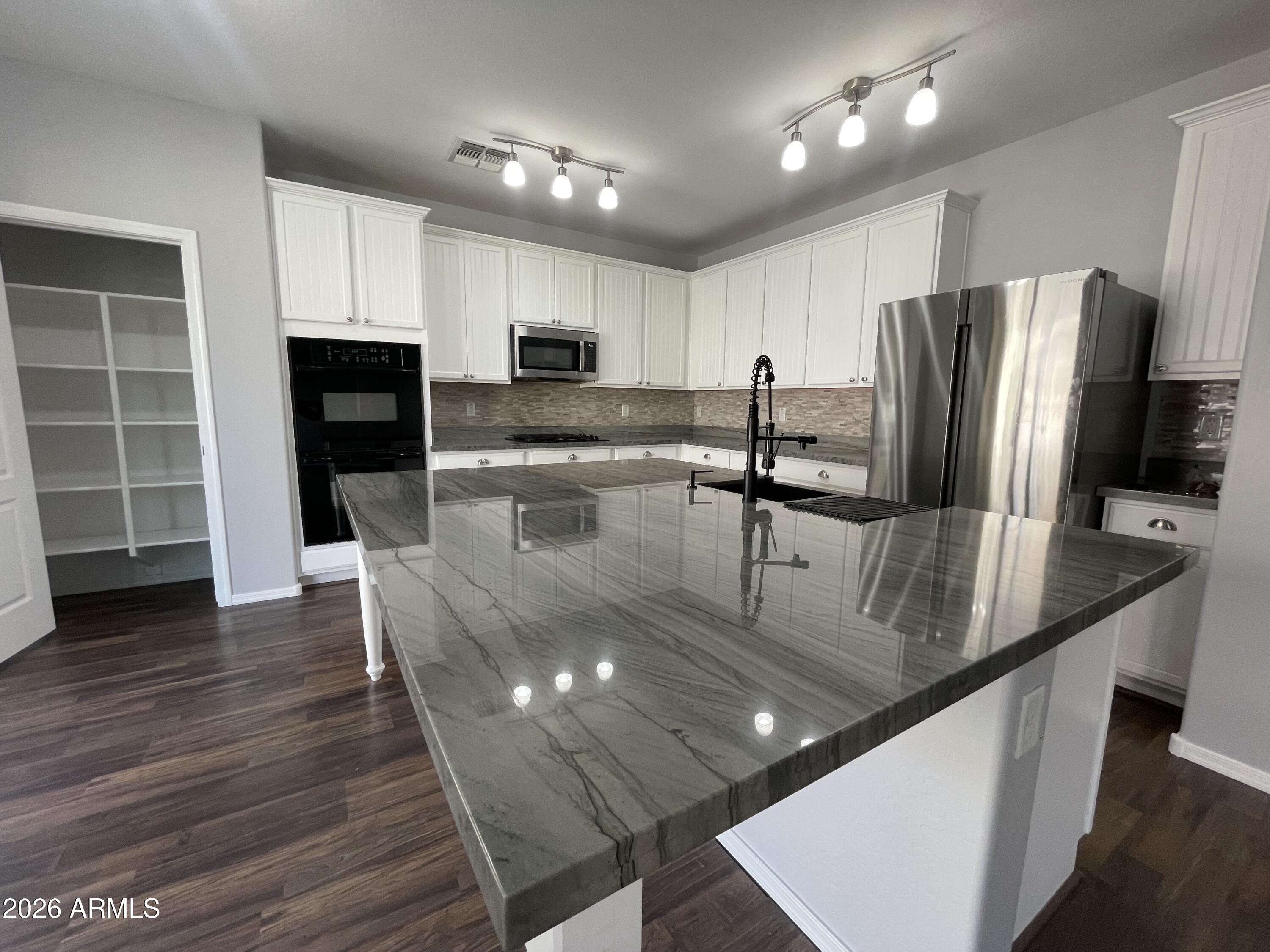 3448 East Merrill Avenue Gilbert, AZ 85234 - Photo 13 of 26 a kitchen with stainless steel appliances granite countertop a sink a stove and a refrigerator