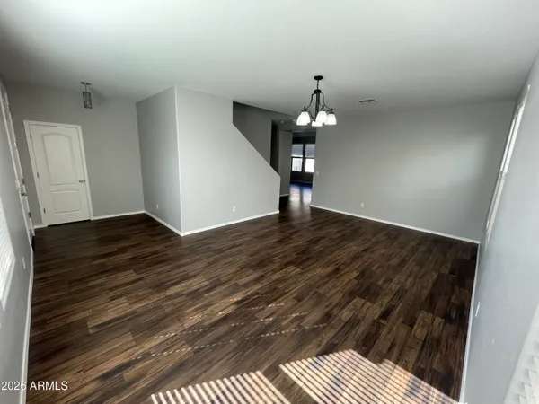 wooden floor in an empty room with a chandelier