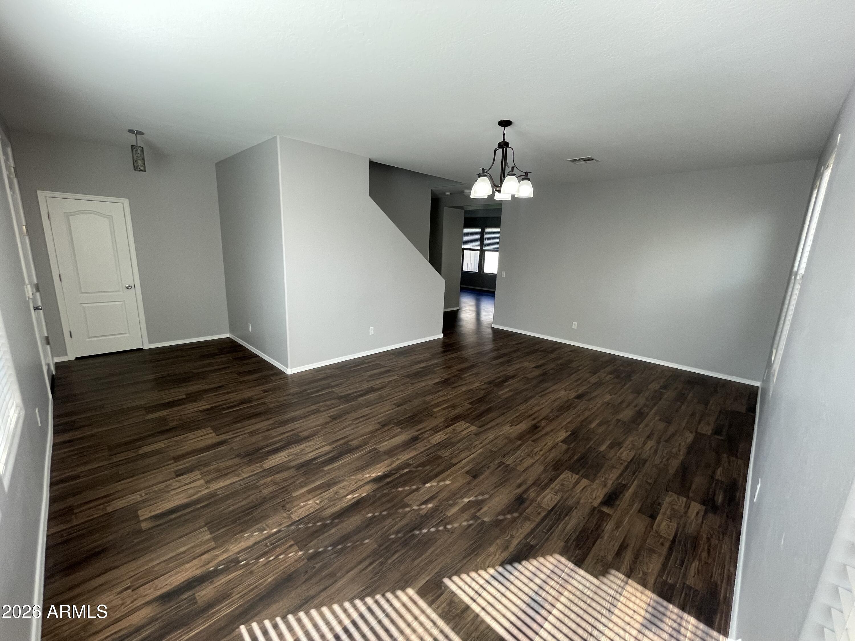 3448 East Merrill Avenue Gilbert, AZ 85234 - Photo 16 of 26 wooden floor in an empty room with a chandelier
