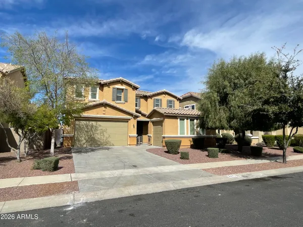 a view of a white house with a large tree with wooden fence