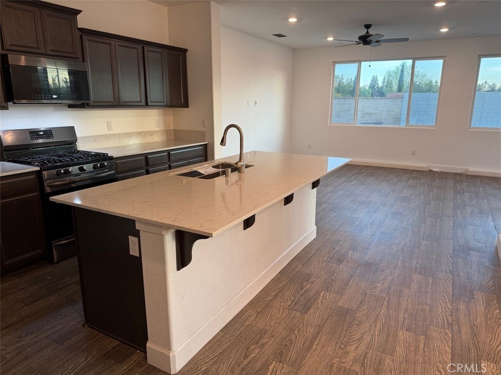 2415 Explorador Drive Merced, CA 95340 - Photo 18 of 28 a kitchen with stainless steel appliances a sink a stove and a wooden floors
