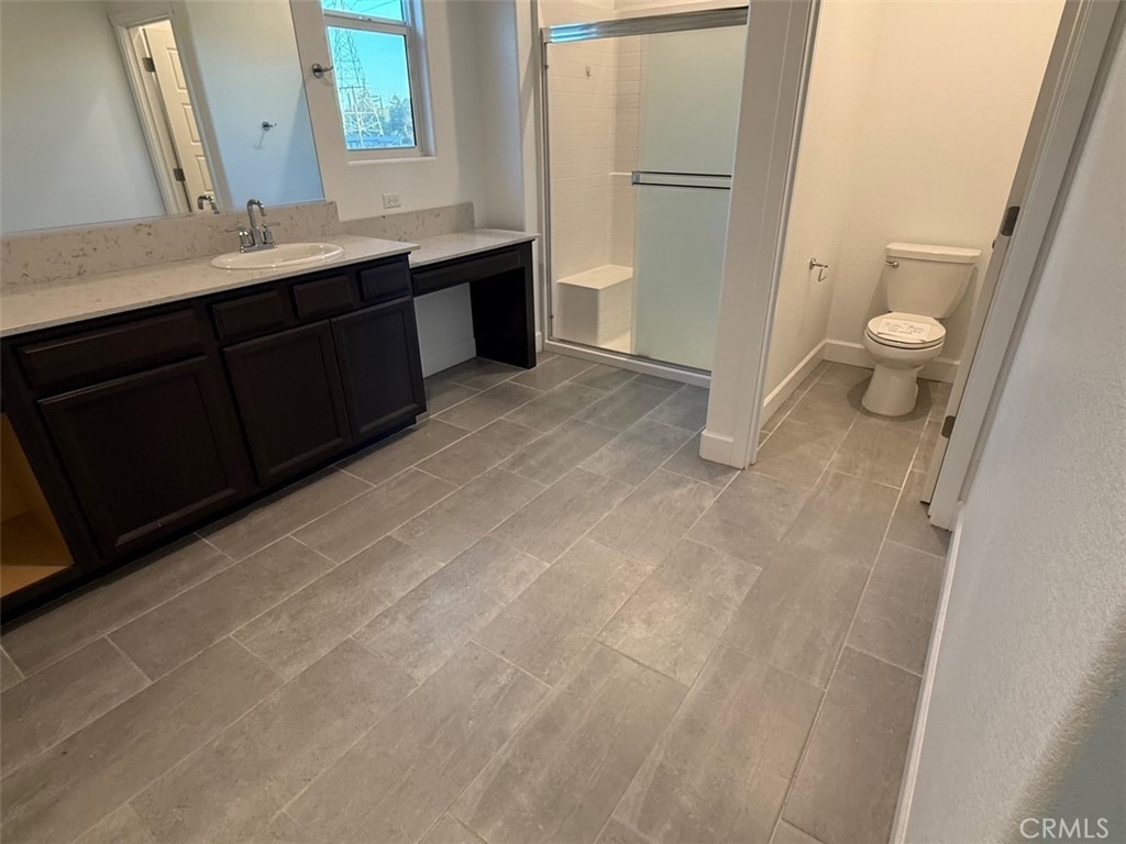 2415 Explorador Drive Merced, CA 95340 - Photo 21 of 28 a bathroom with a granite countertop sink toilet and shower