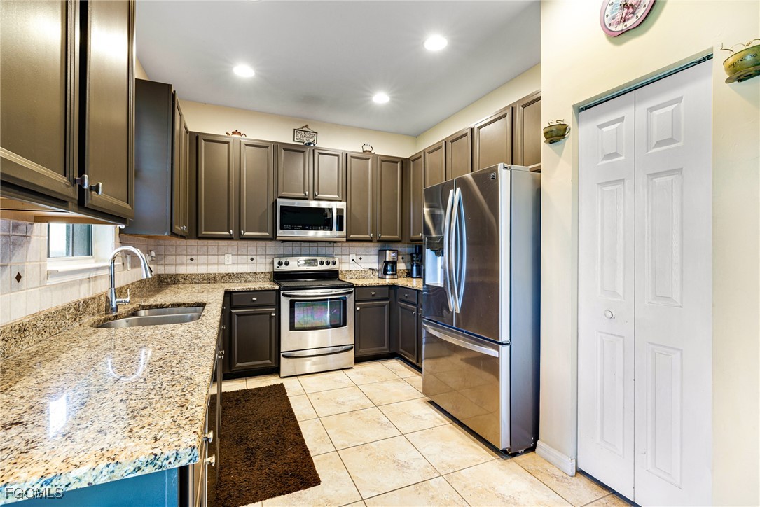 8657 Sumner Avenue Fort Myers, FL 33908 - Photo 8 of 29 a kitchen with granite countertop a refrigerator and a sink