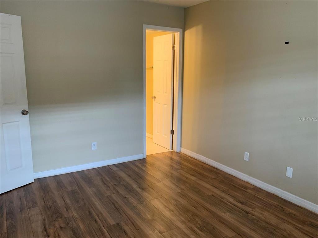 233 Red Maple Place, Unit 233 Brandon, FL 33510 - Photo 2 of 16 a view of an empty room with wooden floor and a window