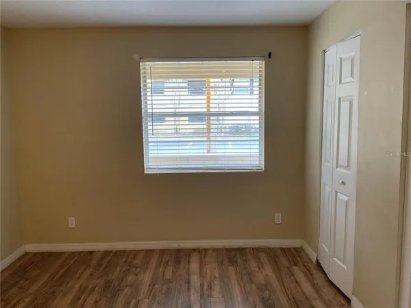 a view of a room with wooden floor and a window