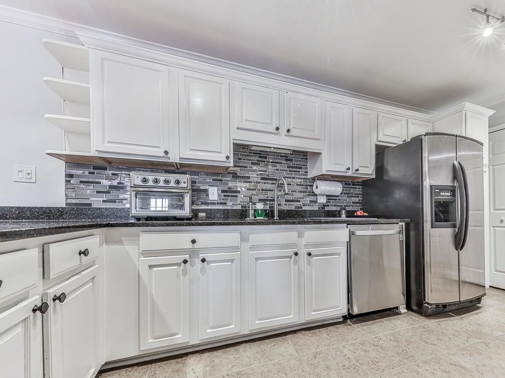 1708 Brighton Point Atlanta, GA 30328 - Photo 10 of 31 a kitchen with stainless steel appliances granite countertop a sink a refrigerator and white cabinets