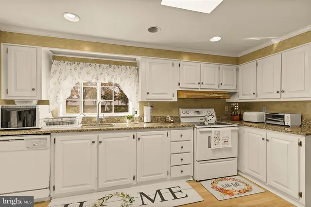 a kitchen with granite countertop white cabinets and white appliances