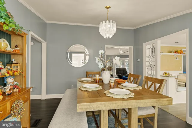 a view of a dining room with furniture a chandelier and wooden floor