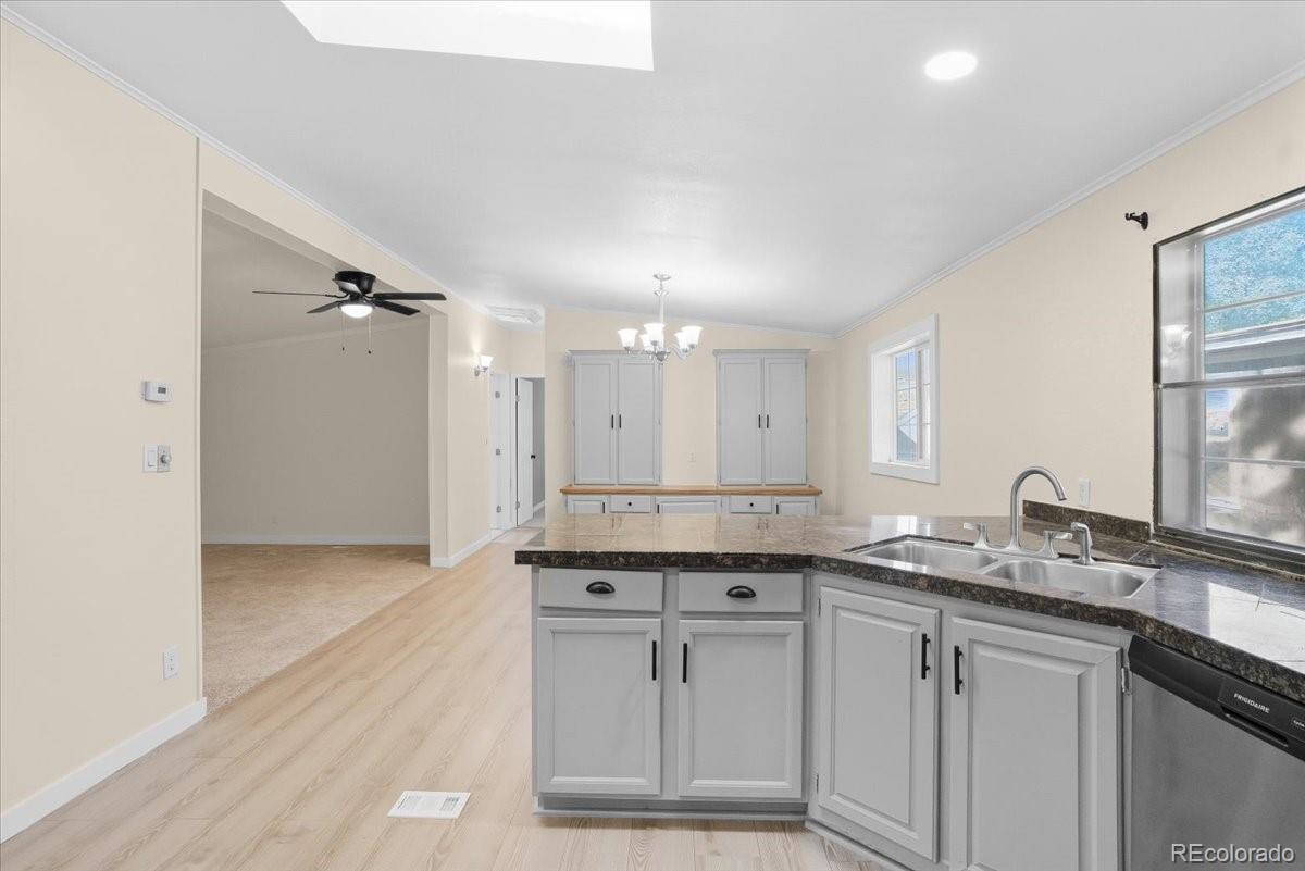 218 Grape Street Hudson, CO 80642 - Photo 11 of 22 a kitchen with granite countertop a sink cabinets and stainless steel appliances
