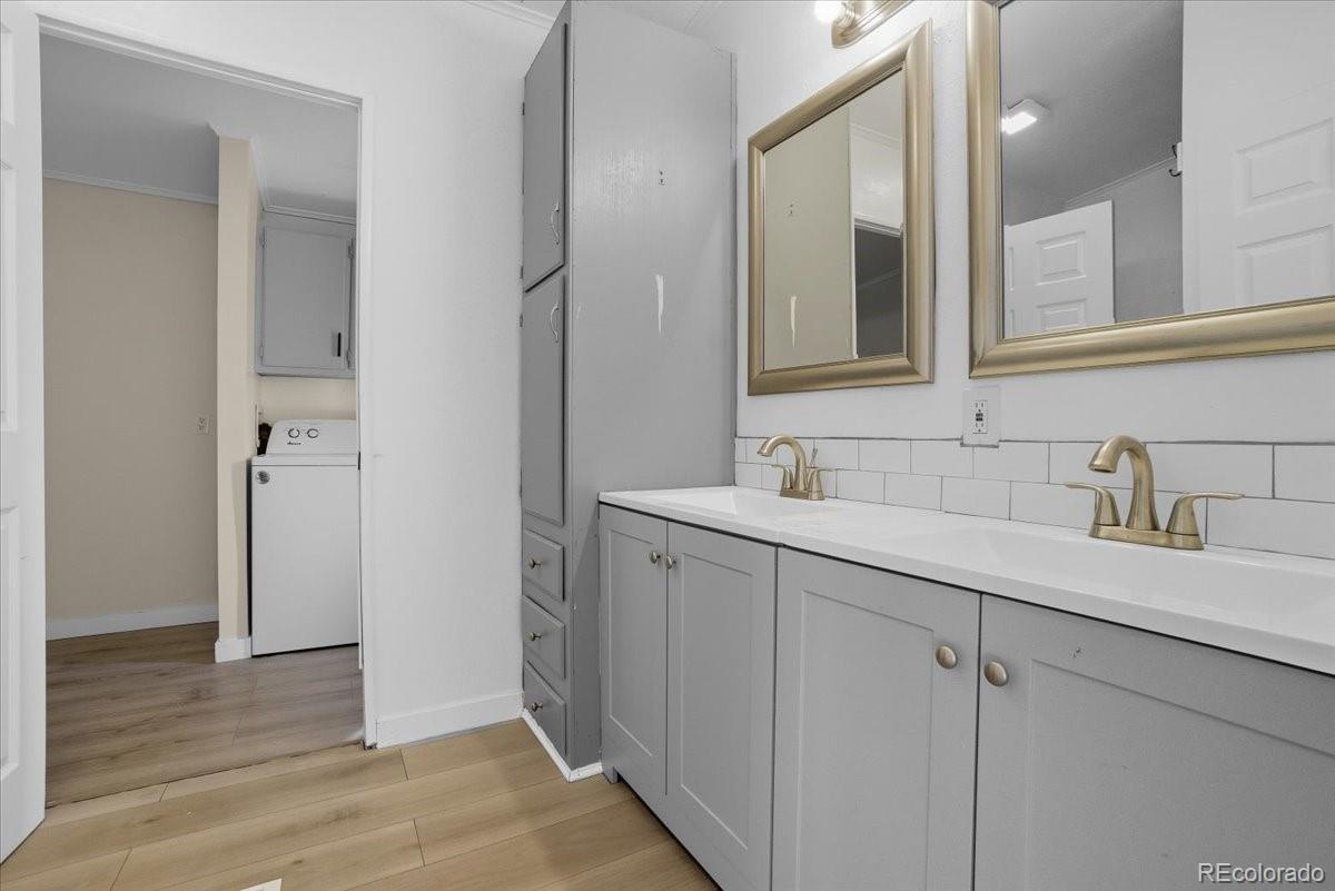 218 Grape Street Hudson, CO 80642 - Photo 9 of 22 a bathroom with a double vanity sink and mirror