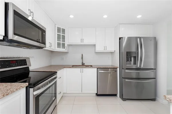 a kitchen with stainless steel appliances granite countertop a refrigerator stove and microwave