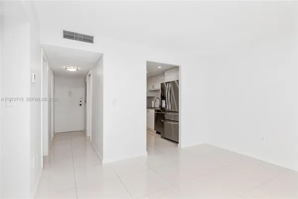 a view of a kitchen with refrigerator and white cabinets