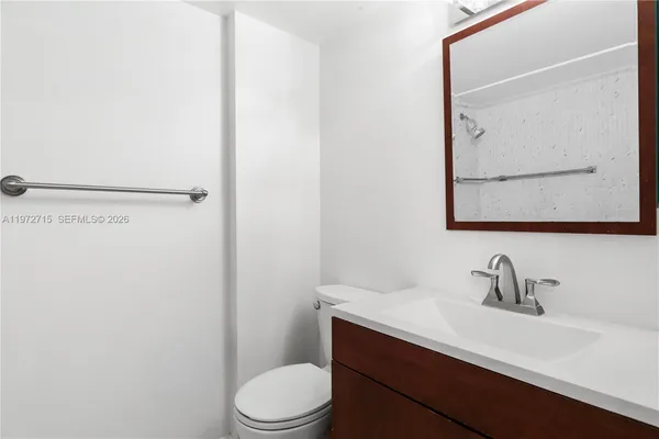 a bathroom with a toilet a sink and mirror