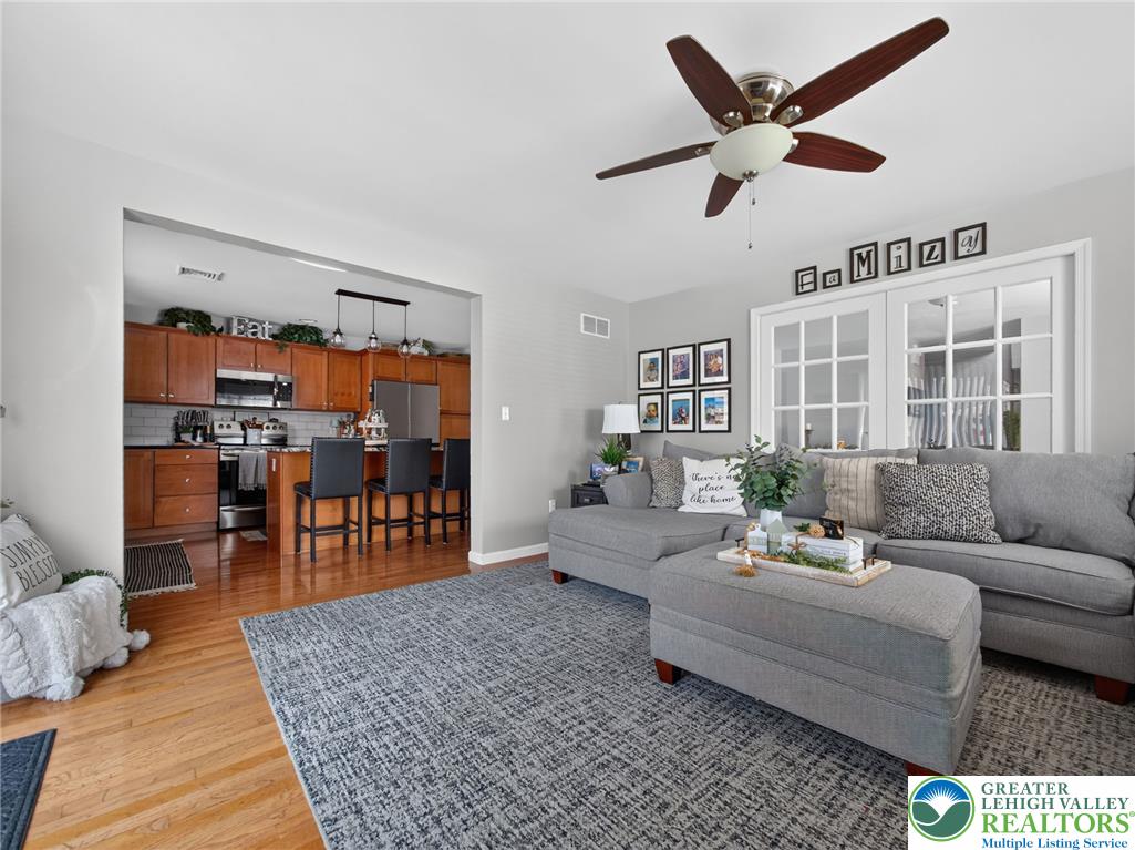 4148 Ross Road Bethlehem, PA 18020 - Photo 26 of 67 An open concept living area transitions smoothly into a modern kitchen, featuring French doors and a ceiling fan.
