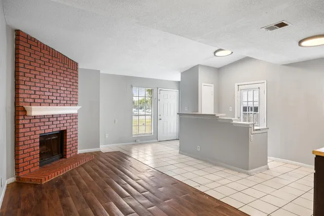 a view of a livingroom with wooden floor and a fireplace