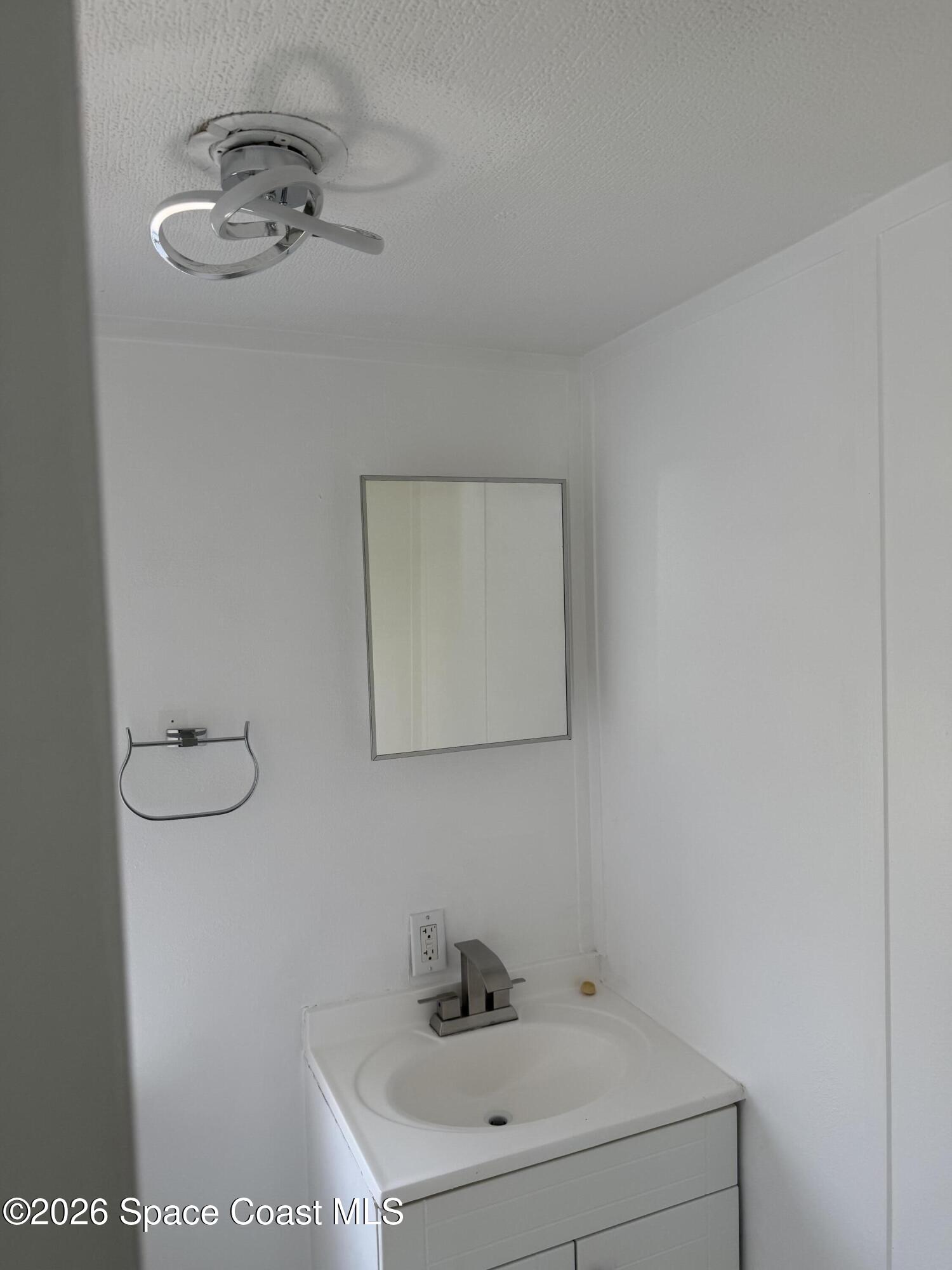 2132 Rocway Drive Melbourne, FL 32935 - Photo 8 of 16 a bathroom with a sink a mirror and vanity