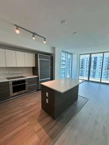 a large kitchen with stainless steel appliances a large counter top and a stove top oven