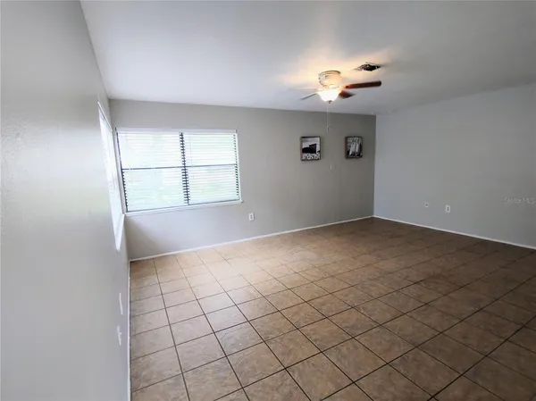 a living room with furniture a flat screen tv and a window