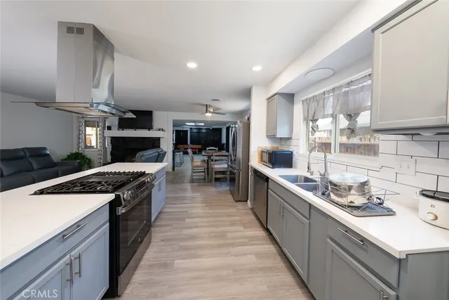 a large kitchen with stainless steel appliances granite countertop a lot of counter space and wooden floors