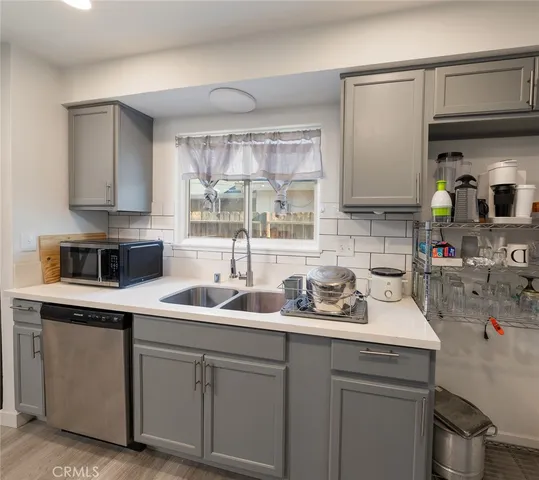 a kitchen with sink a stove and cabinets