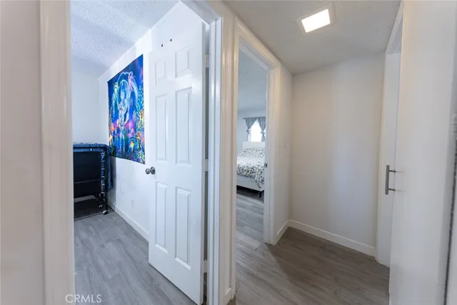 a view of a hallway with wooden floor and closet area