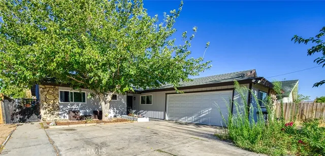 a backyard of a house with table and chairs and potted plants