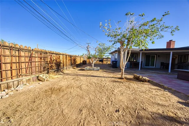 a backyard of a house with table and chairs