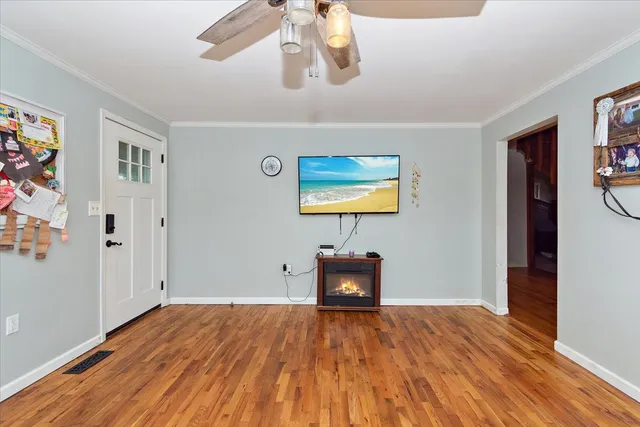 a kitchen with stainless steel appliances granite countertop a stove a sink and white cabinets with wooden floor
