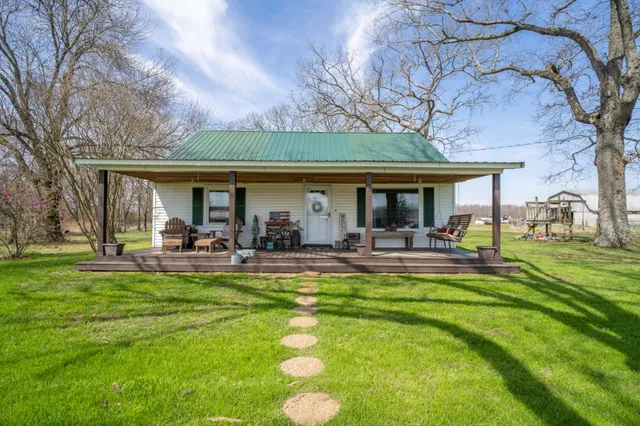 a front view of a house with yard patio and green space