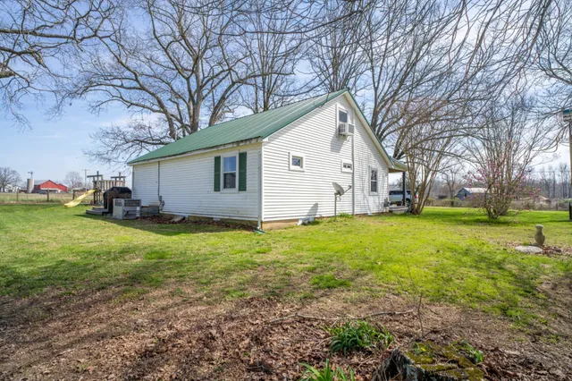 a view of a house with backyard and trees