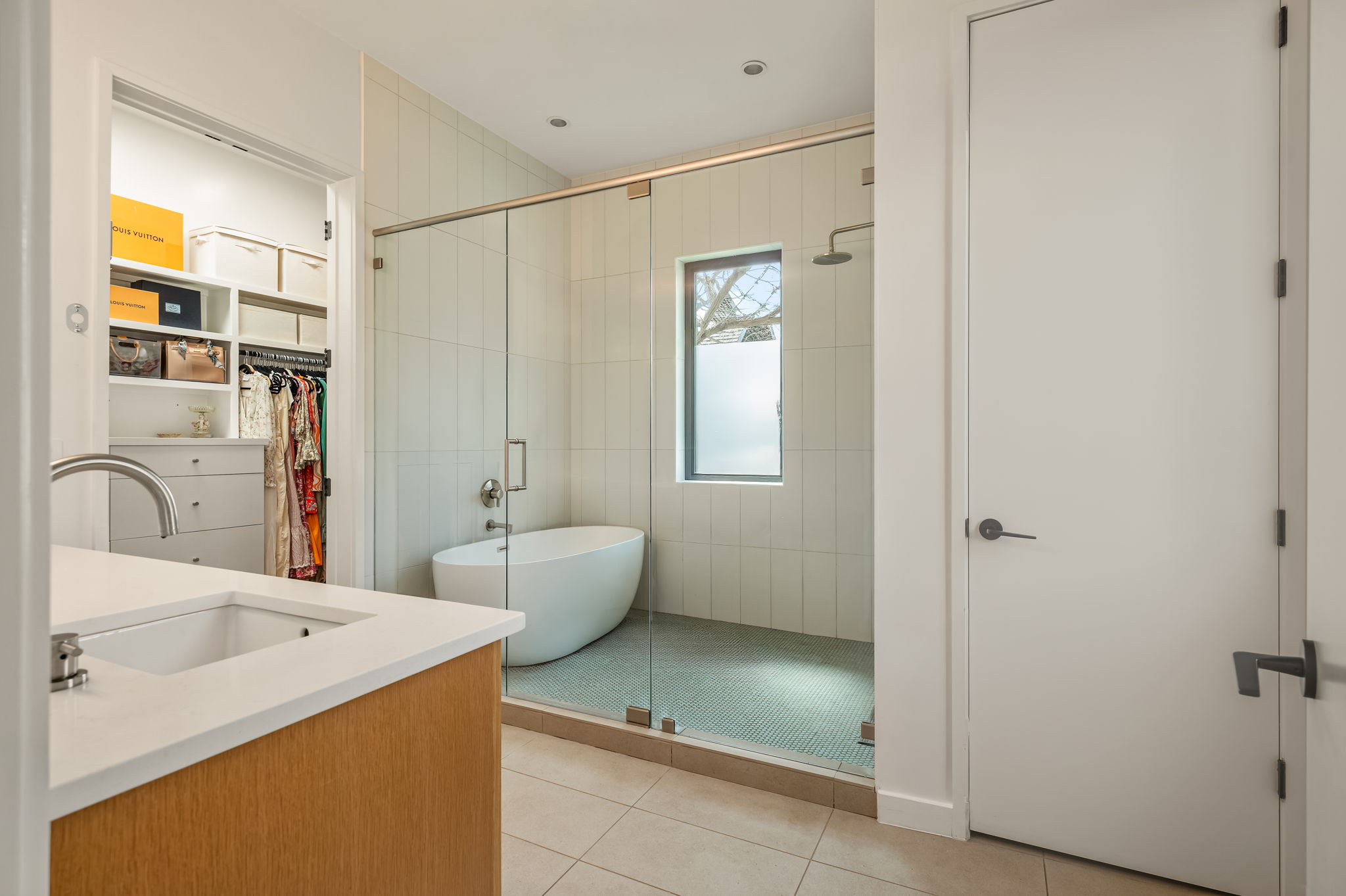 1811 Collier Street Austin, TX 78704 - Photo 17 of 40 Bathroom with vanity, a shower stall, a walk in closet, light tile patterned floors, and a soaking tub