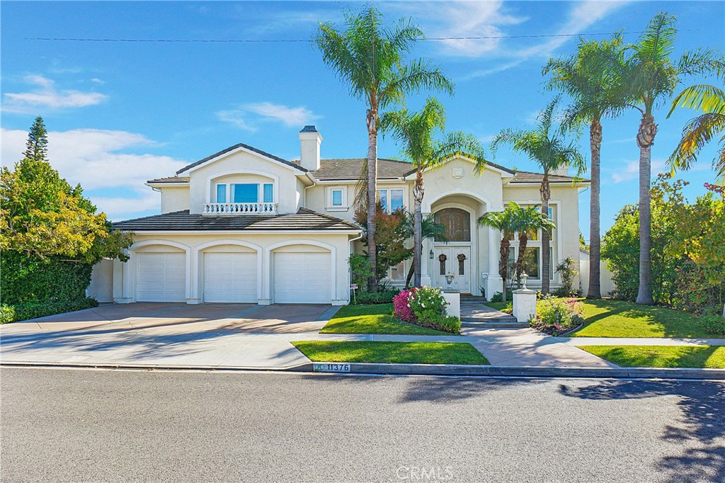 11376 Loch Lomond Road Los Alamitos, CA 90720 - Photo 1 of 32 a front view of a house with a garden and trees