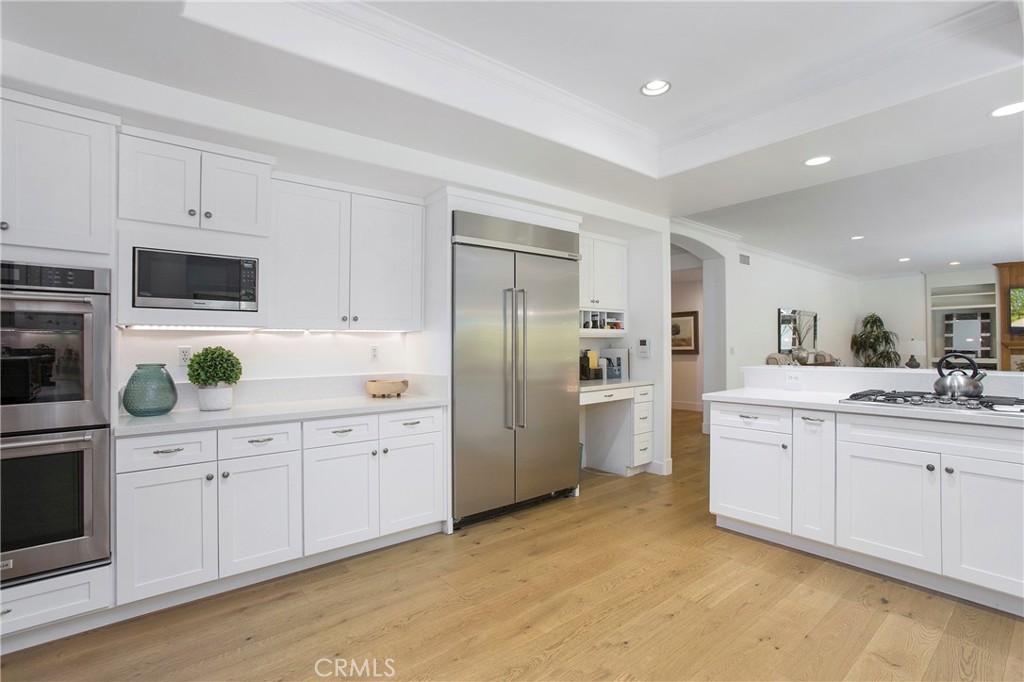 11376 Loch Lomond Road Los Alamitos, CA 90720 - Photo 13 of 32 a kitchen with white cabinets and stainless steel appliances