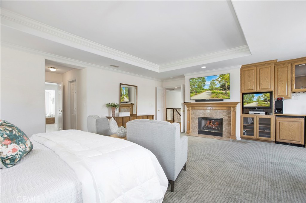 11376 Loch Lomond Road Los Alamitos, CA 90720 - Photo 18 of 32 a spacious bedroom with a bed and a fireplace