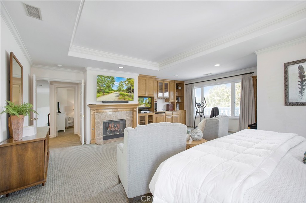 11376 Loch Lomond Road Los Alamitos, CA 90720 - Photo 19 of 32 a large bedroom with furniture a fireplace and a window