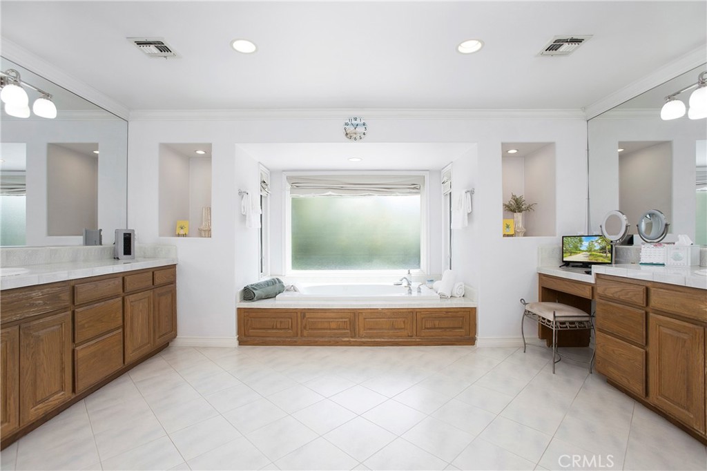 11376 Loch Lomond Road Los Alamitos, CA 90720 - Photo 20 of 32 a spacious bathroom with a tub sink and mirror