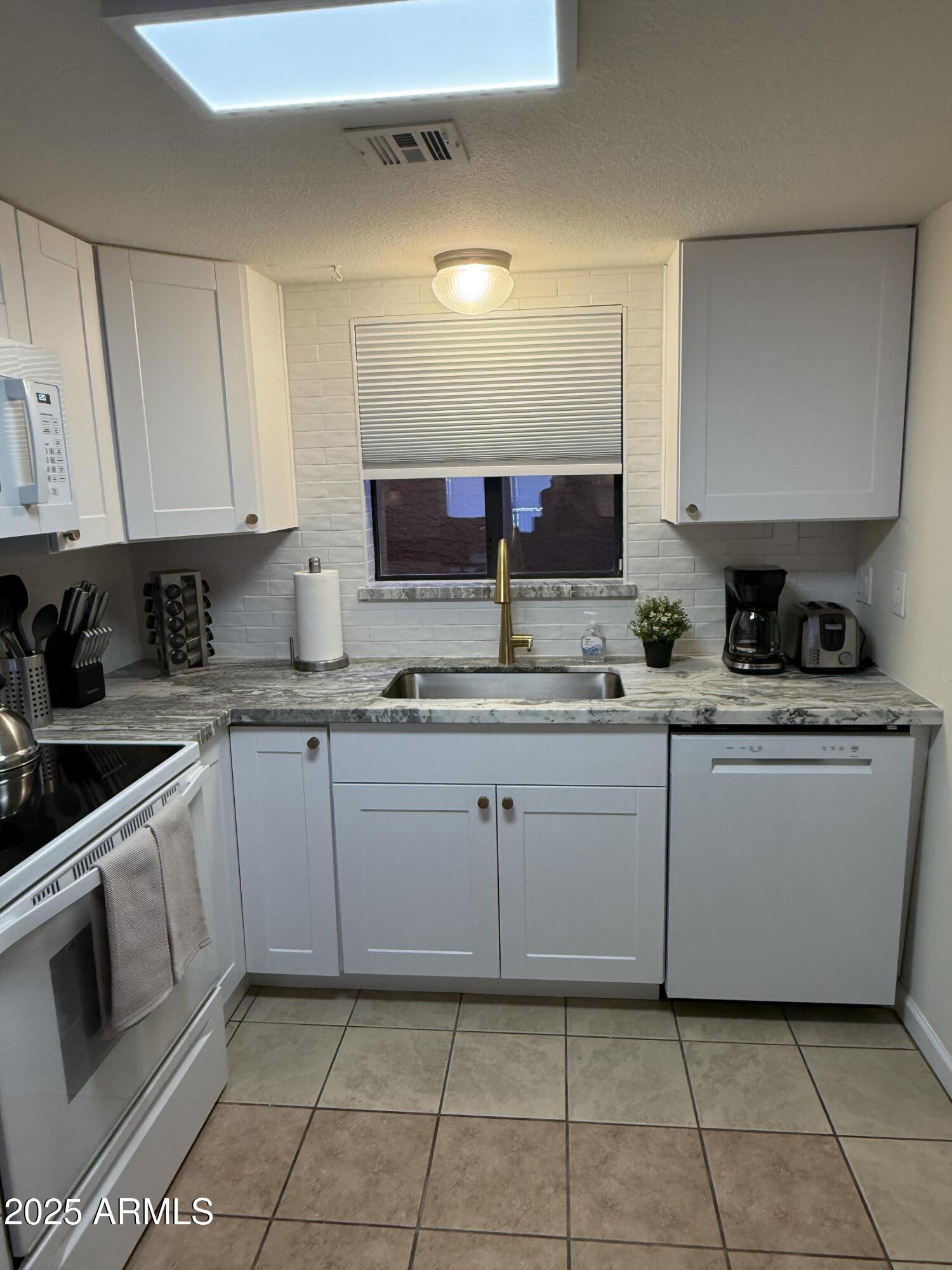 540 South West Road, Unit 24 Wickenburg, AZ 85390 - Photo 3 of 23 a kitchen with a sink a stove and cabinets