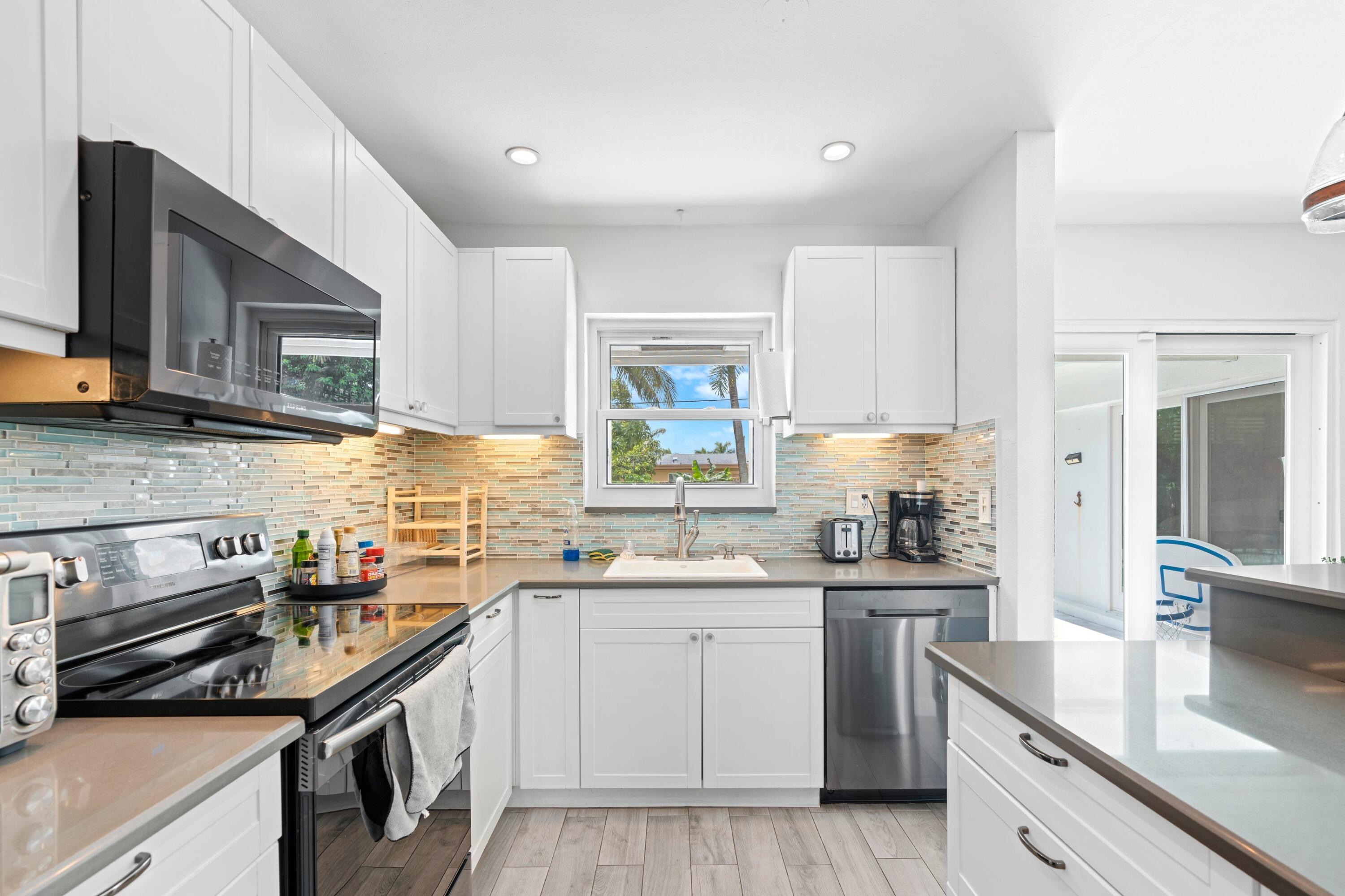 226 Southwest 13th Avenue Boynton Beach, FL 33435 - Photo 3 of 16 a kitchen that has a sink and a stove in it