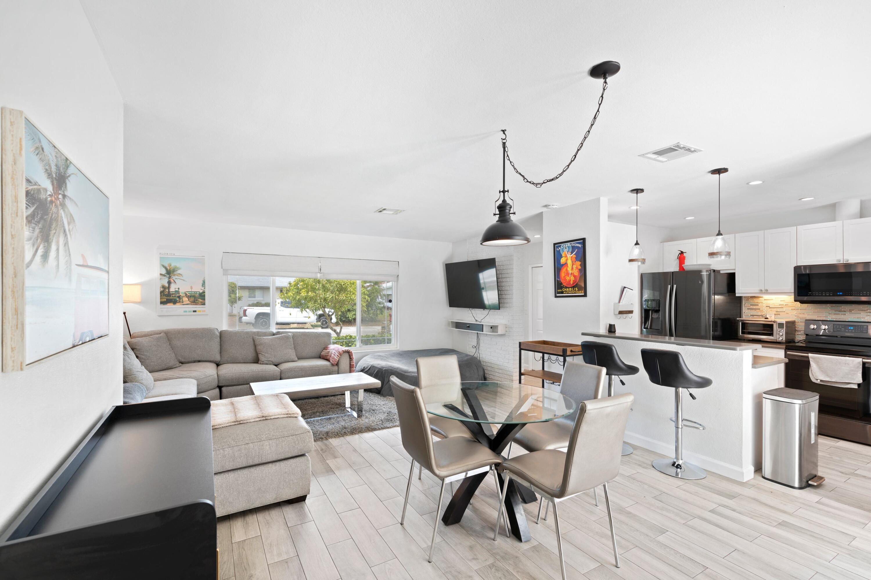 226 Southwest 13th Avenue Boynton Beach, FL 33435 - Photo 7 of 16 a living room with furniture a flat screen tv and a floor to ceiling window