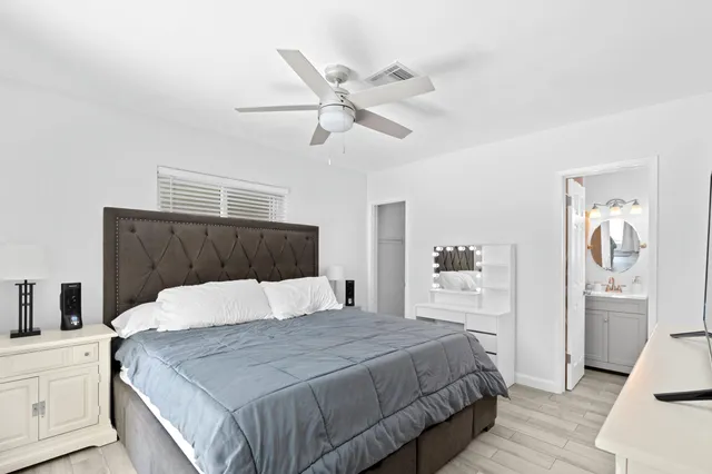 a bedroom with a large bed and a chandelier