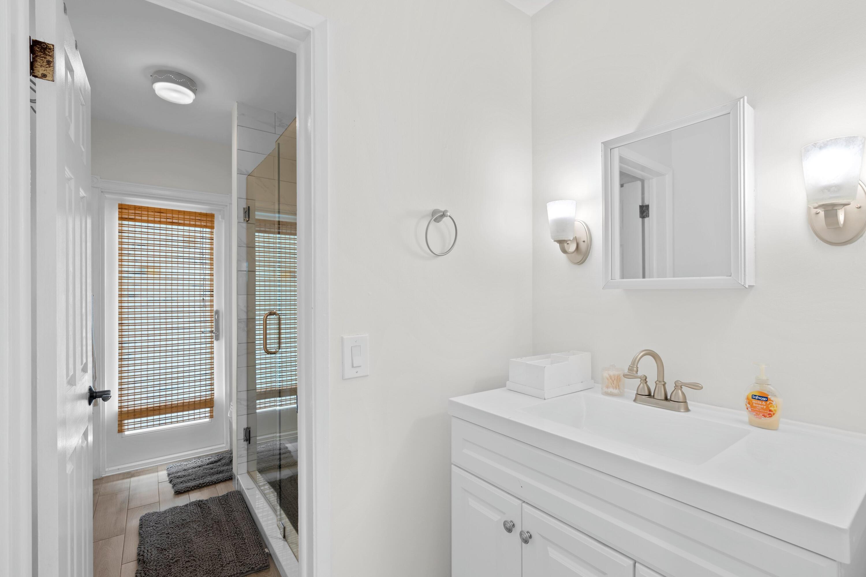 226 Southwest 13th Avenue Boynton Beach, FL 33435 - Photo 10 of 16 a en suite bathroom with a sink a mirror and a shower