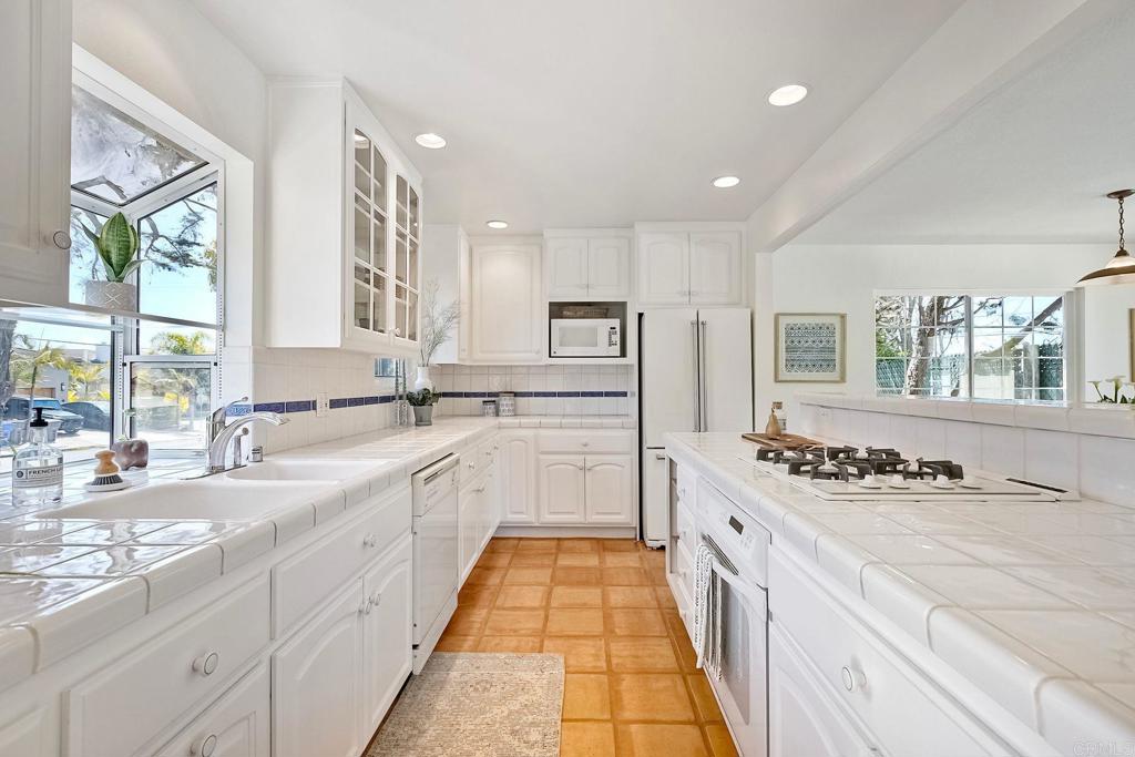 3897 Park Drive Carlsbad, CA 92008 - Photo 16 of 39 a kitchen with stainless steel appliances a stove a sink and white cabinets