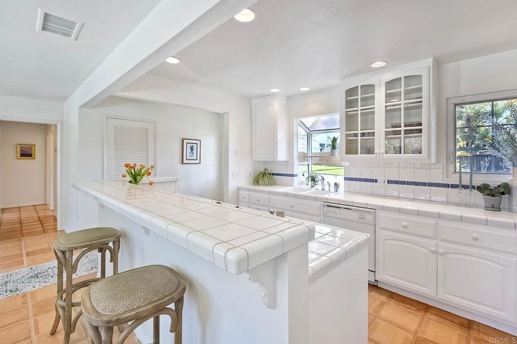 3897 Park Drive Carlsbad, CA 92008 - Photo 17 of 39 a kitchen with a stove a sink a dining table and chairs