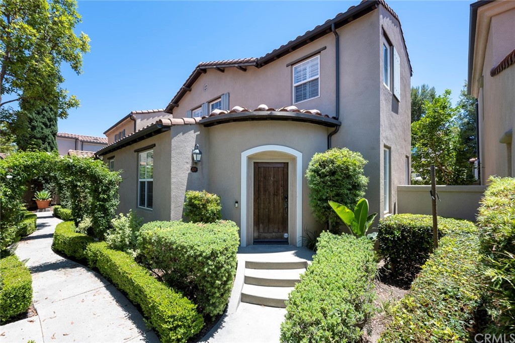 a house with a flower garden and potted plants