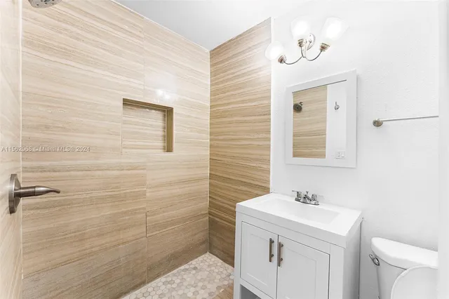 a bathroom with a sink a toilet and mirror