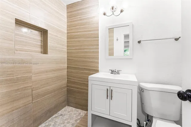 a bathroom with a sink a toilet and mirror