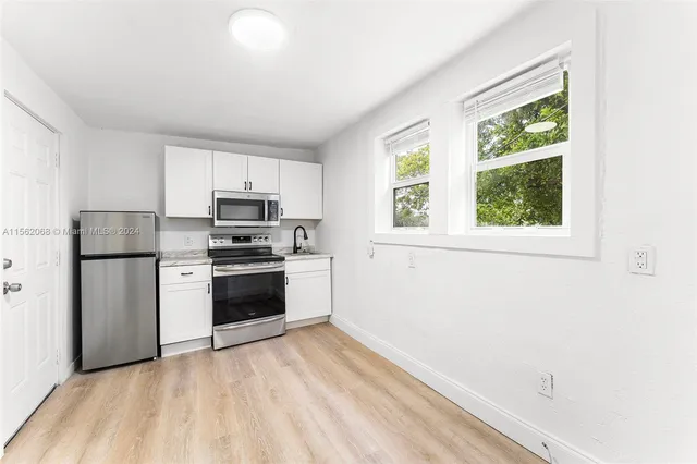 a kitchen with a stove a sink and a window