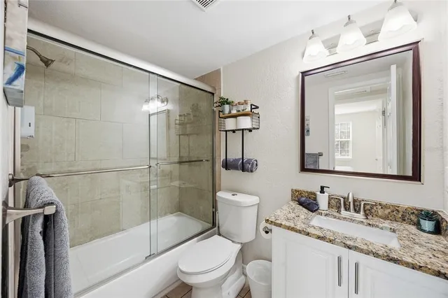 a bathroom with a granite countertop sink toilet and shower