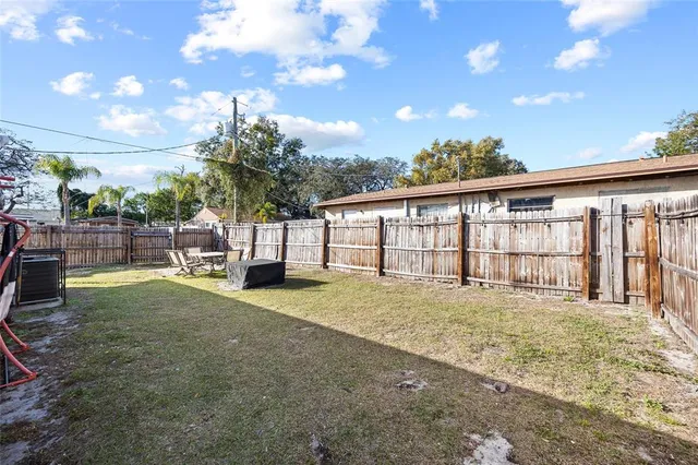 a view of an house with backyard and a tree